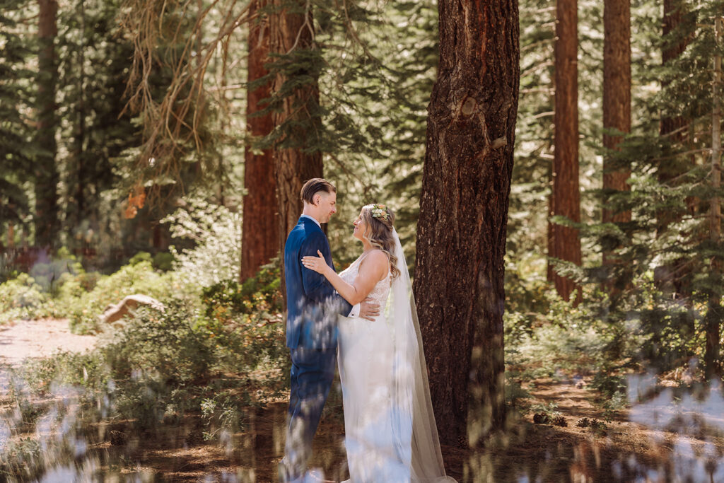 Lake Tahoe, California mountain, forest and beach wedding with the most beautiful views. This was considered a fairly intimate small wedding. The views did not disappoint and neither did the bride in her gorgeous romantic A-Line wedding dress. It was beautifully complimented by the nature trails, trees, wood, and greenery during the forest wedding first look pictures. Photographed by Bay Area photographer, Kati Douglas with Xilo Photography based in Oakland, CA